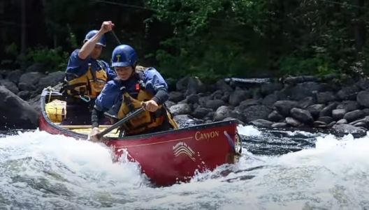 A photo of a canoe in moving water.